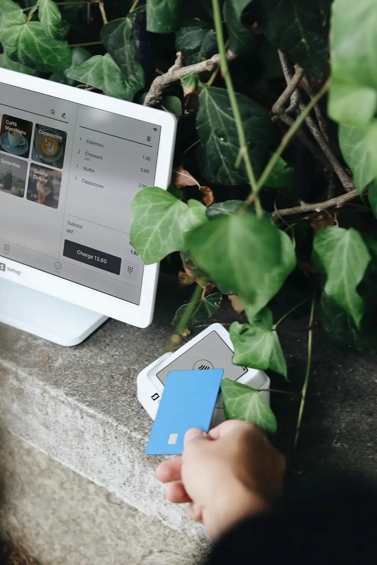 Person holding a payment card next to a card terminal