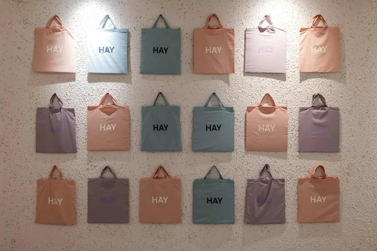 Pastel tote bags arranged on a textured wall